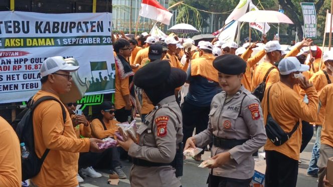 
					Polisi Bagikan Roti dan Air Mineral ke Massa Aksi Petani Tebu di Monas